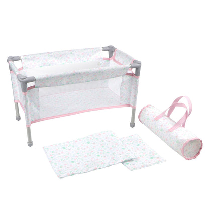 A pink and white checkered doll crib/playpen with a transparent side panel, accompanied by a travel bag and a mattress, set against a white background.