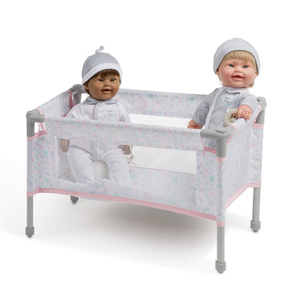 Two dolls in a crib with a white background