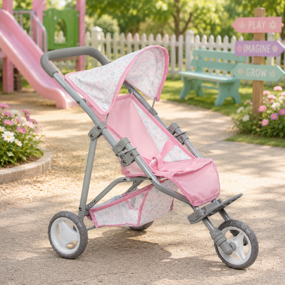 
A folding deluxe jogger for dolls, predominantly pink with gray accents, featuring a floral pattern and a sunshade.
